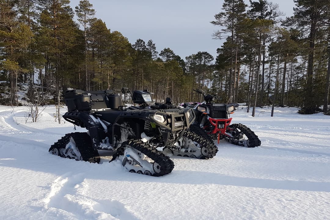 two atvs with tracks in snow